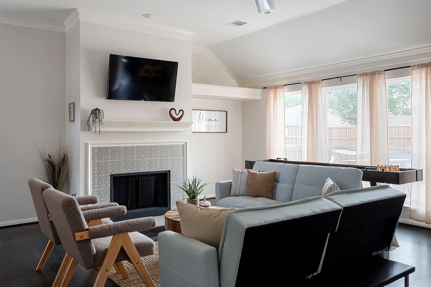 Welcome to our inviting living space with cozy sofas and a sleek TV setup. Shaded windows bring in just the right amount of natural light, creating a perfect balance of comfort and ambiance.
