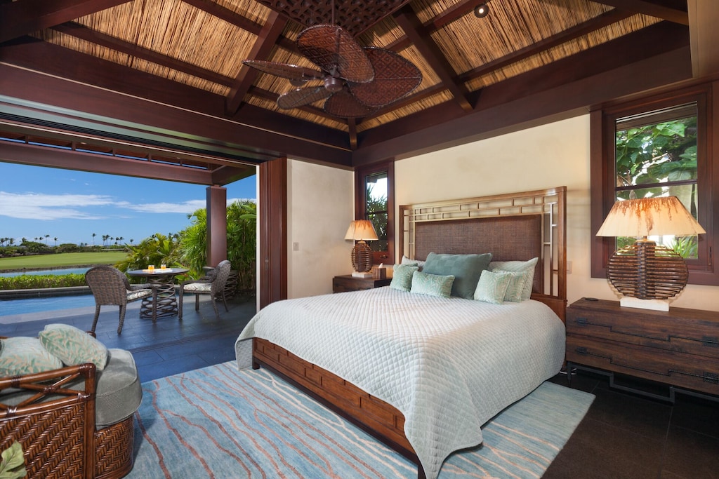 Primary Bedroom features exclusive lanai and ocean views along with ensuite bathroom, double vanity sinks, outdoor shower, and ample closet space.