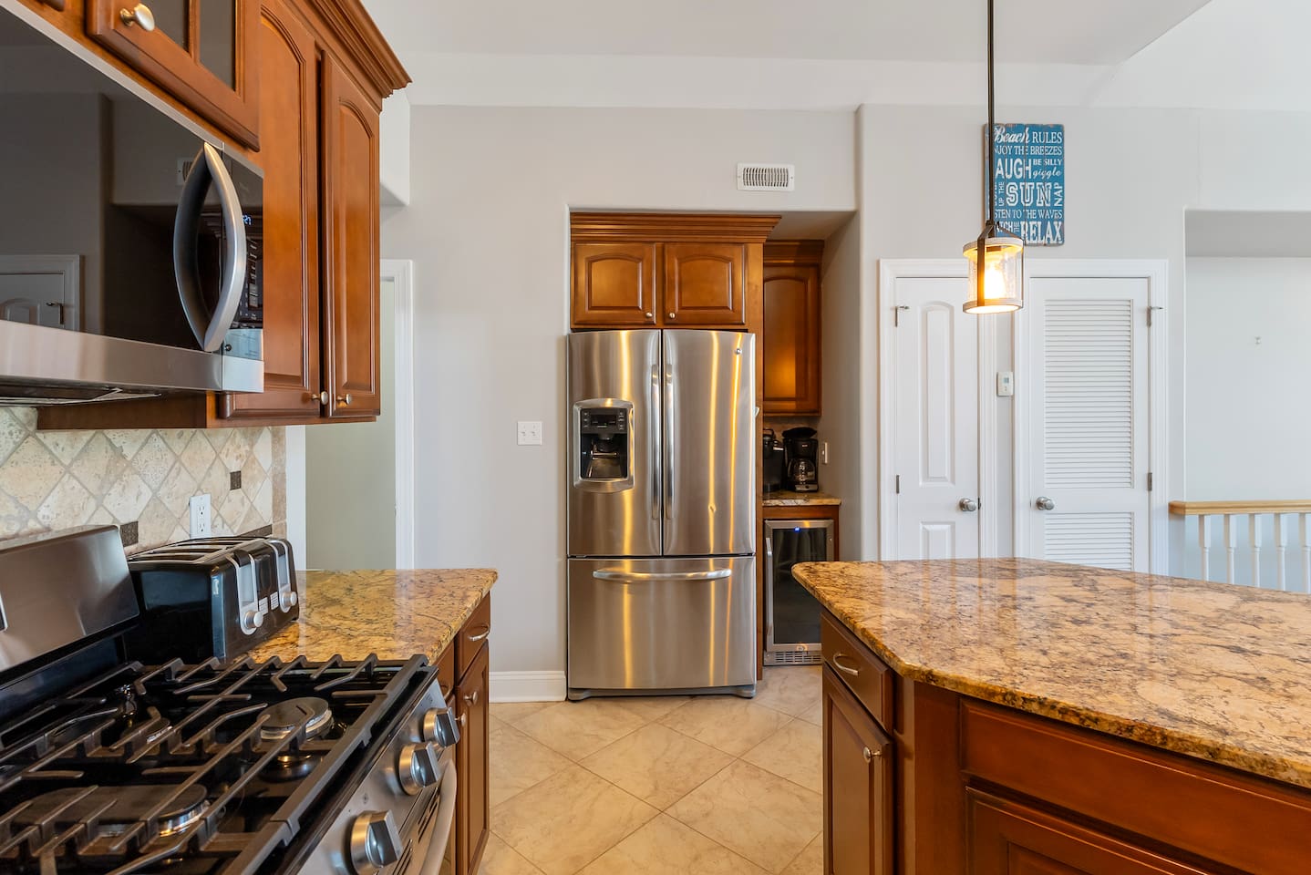 Full kitchen with stainless steel appliances, large island for additional seating, ample prep space and separate beverage refrigerator. 