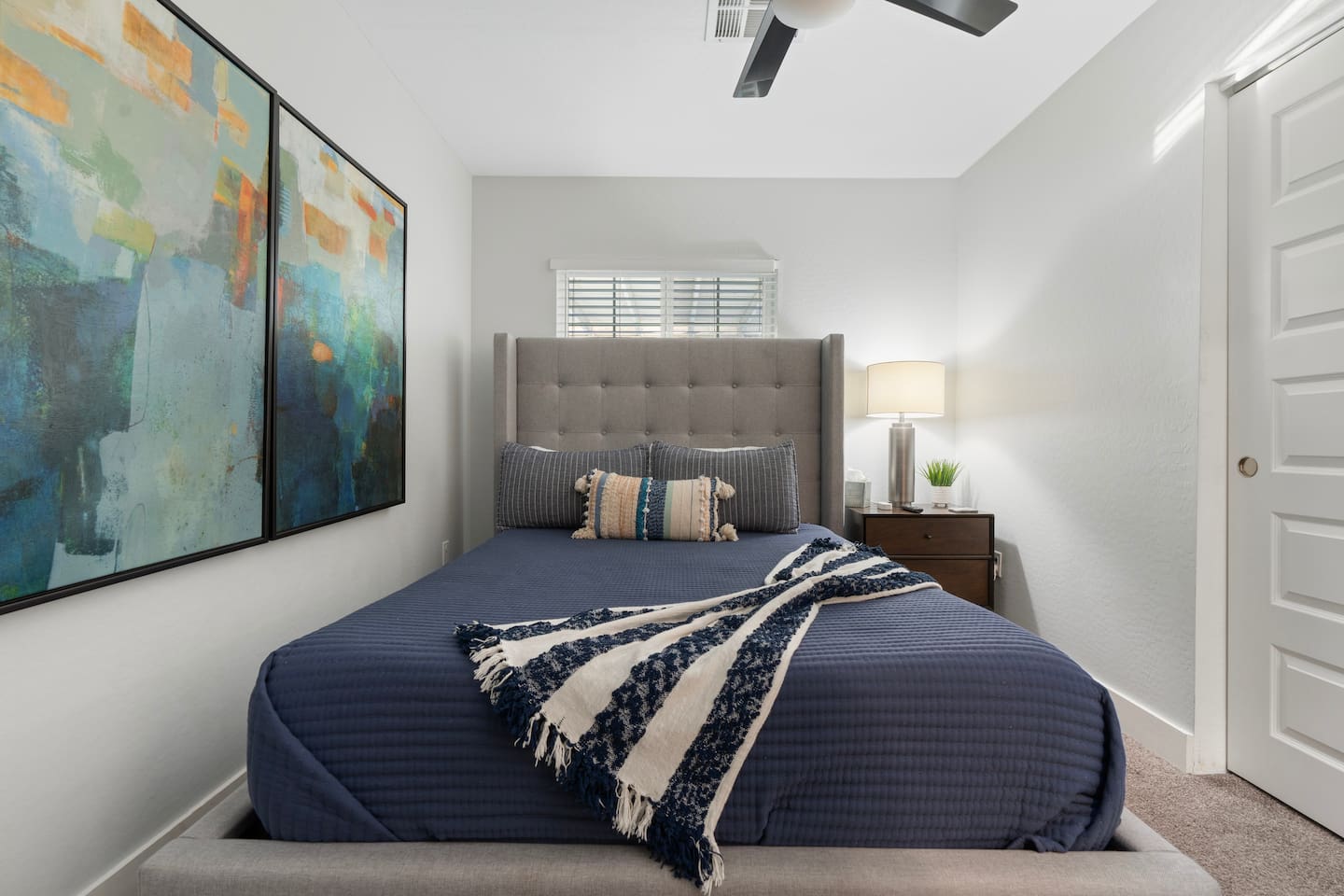 Stylish bedroom featuring a comfortable queen-sized bed, blending modern design with a cozy atmosphere.