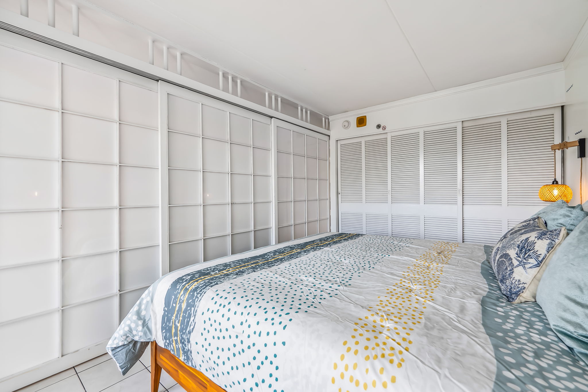 Bedroom angle view showing sliding doors utilized to separate it from the living area for privacy.  Closet located in bedroom