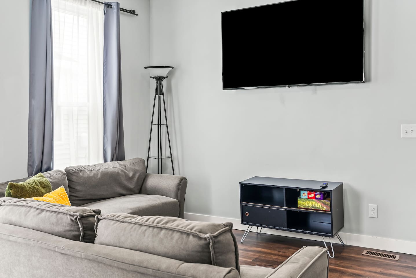 Comfortable living area with ample seating, stylish floor lamp, and easy access to the rest of the apartment.