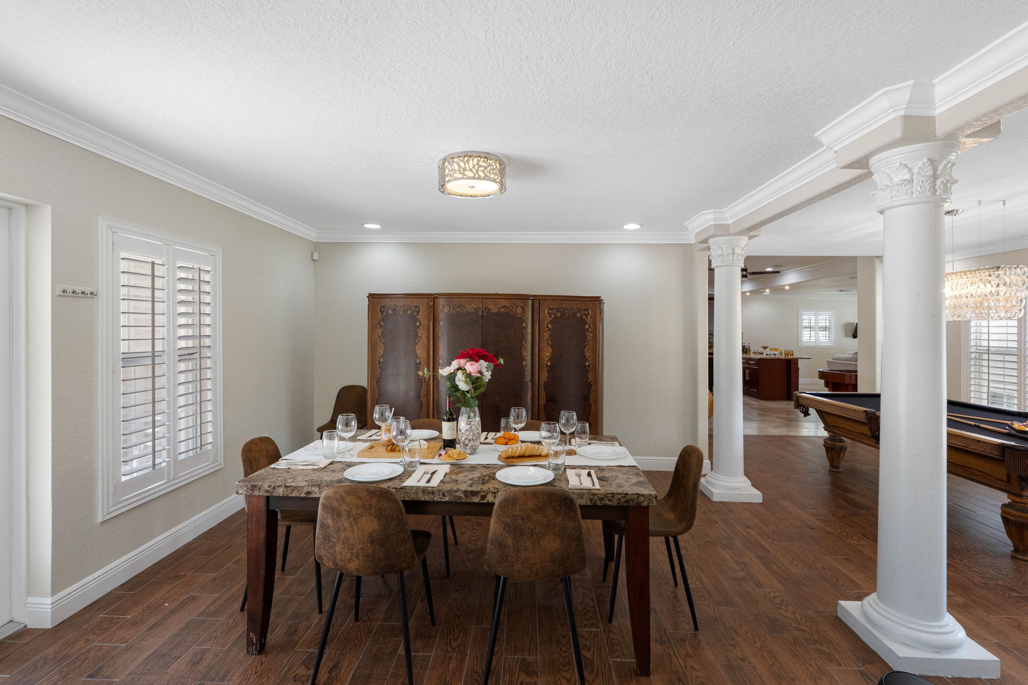 Detailed crown molding and stately columns frame the dining area, adding elegance to every meal enjoyed here.