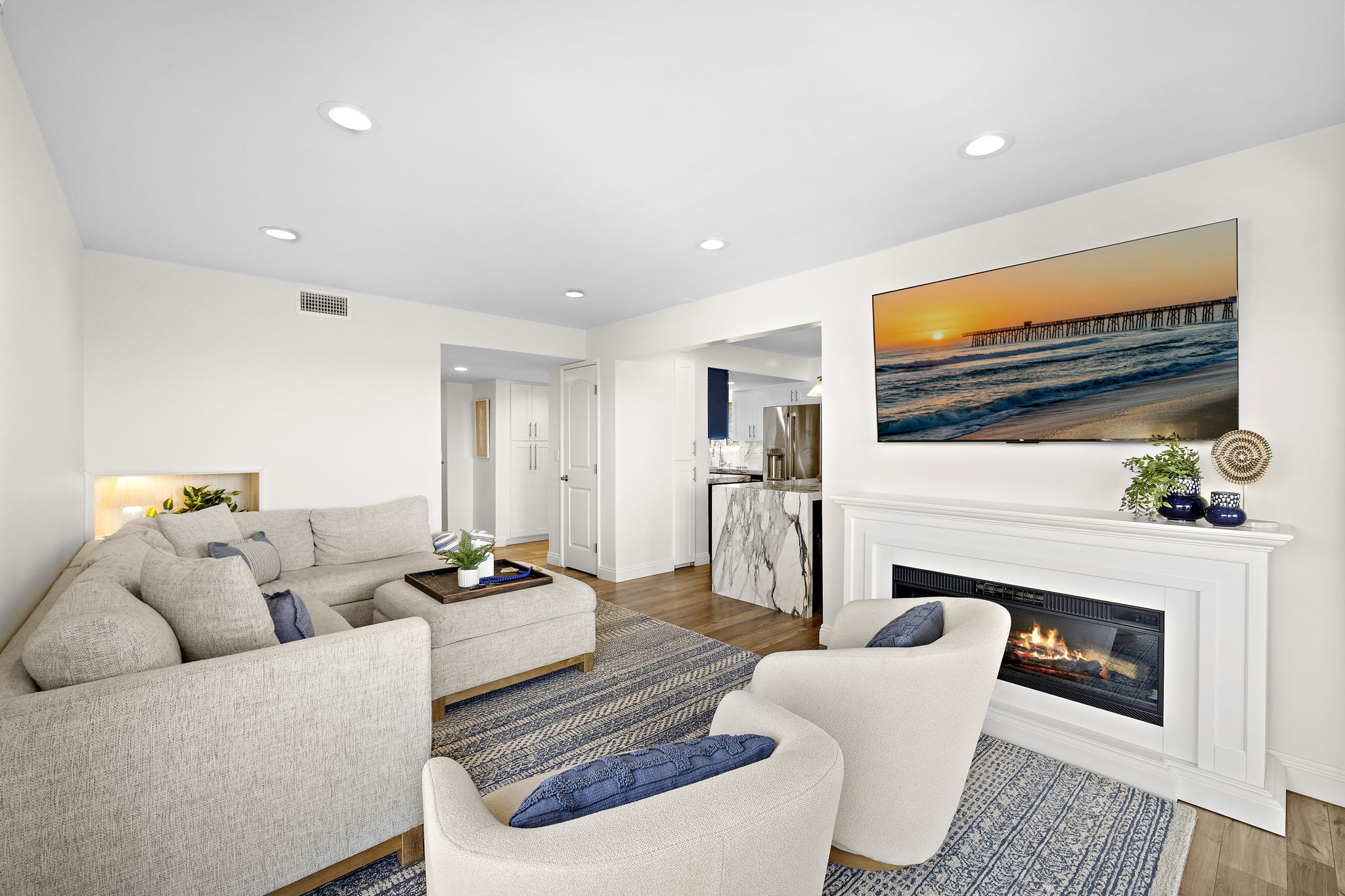 After a day at the beach, unwind in the bright, spacious living room with plush seating, abundant natural light, a cozy fireplace, and a large smart TV with multiple streaming services. The two swivel chairs rotate to take in the view or gather around the 
