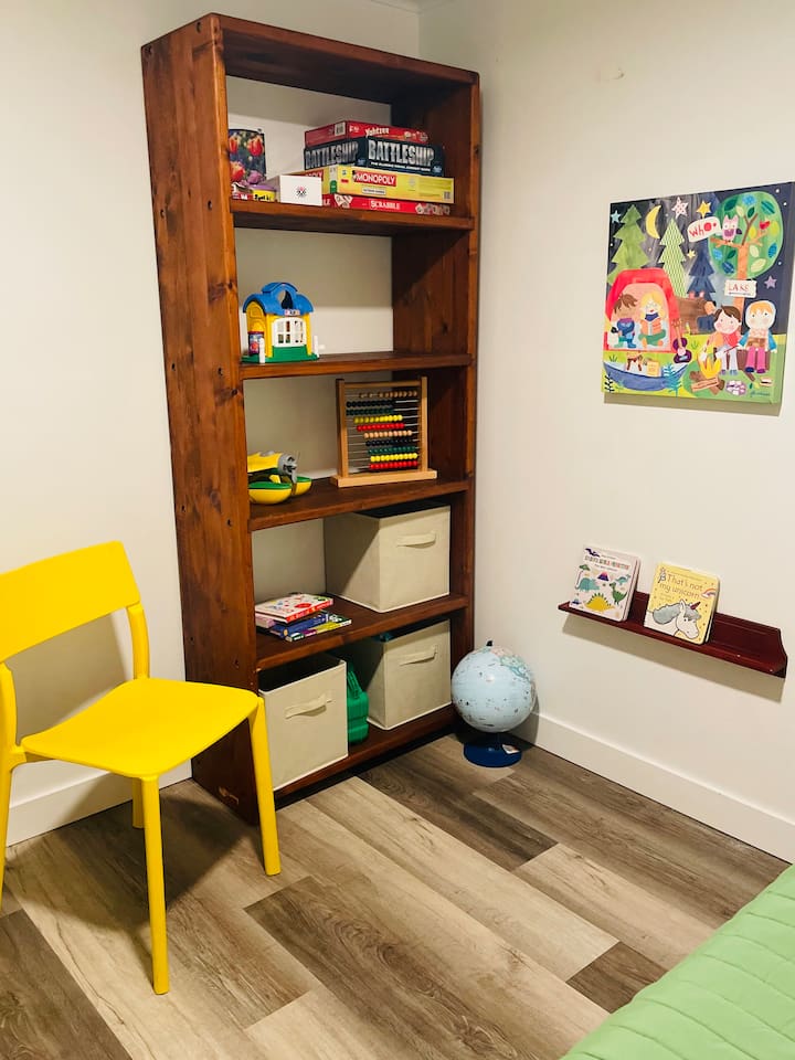 A playful corner filled with books, toys, board games, and puzzles creates a welcoming space where kids can explore, imagine, and enjoy hours of fun.