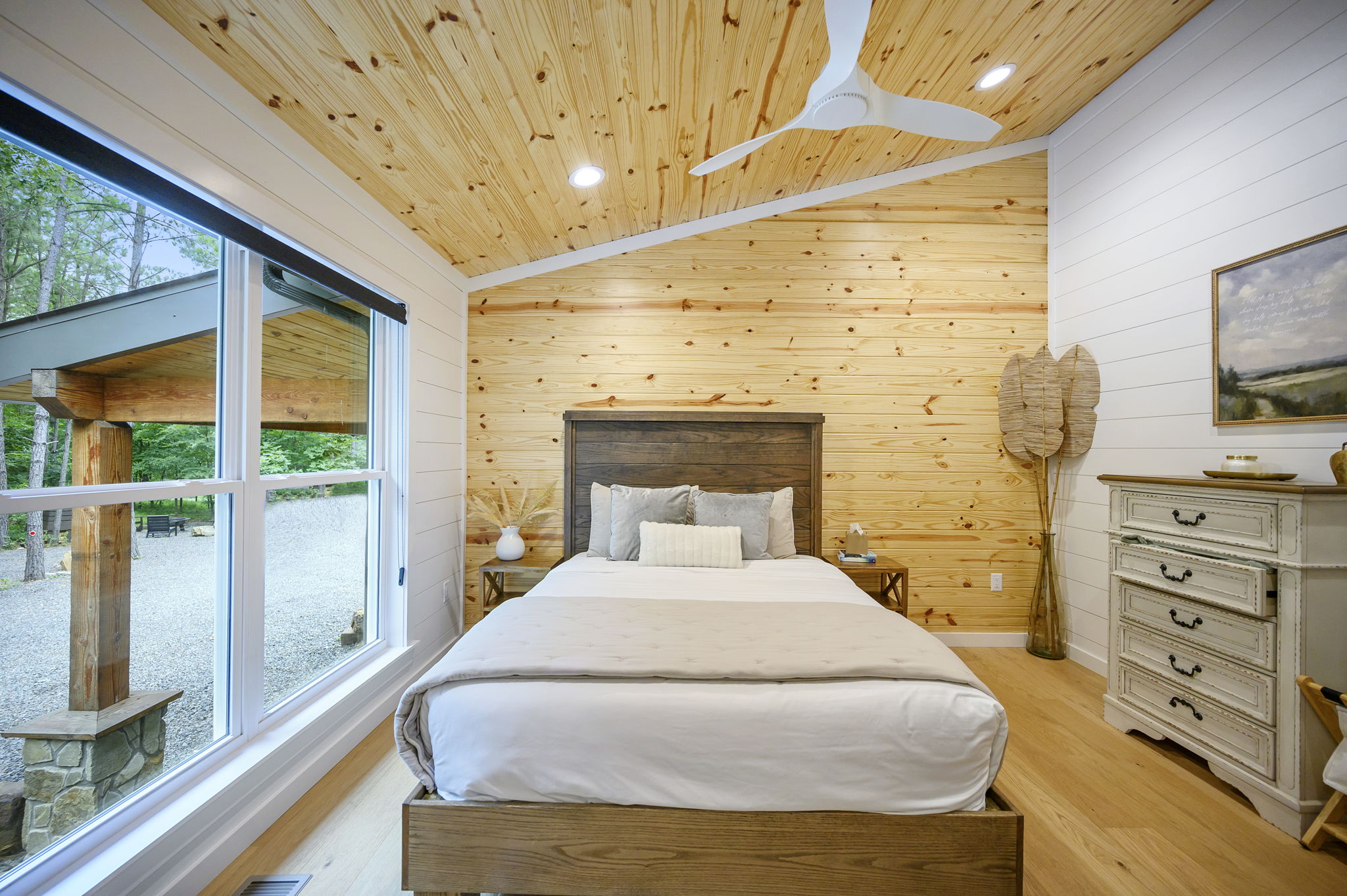 A beautifully appointed queen bedroom featuring luxury design, high-end linens, and peaceful forest views.
