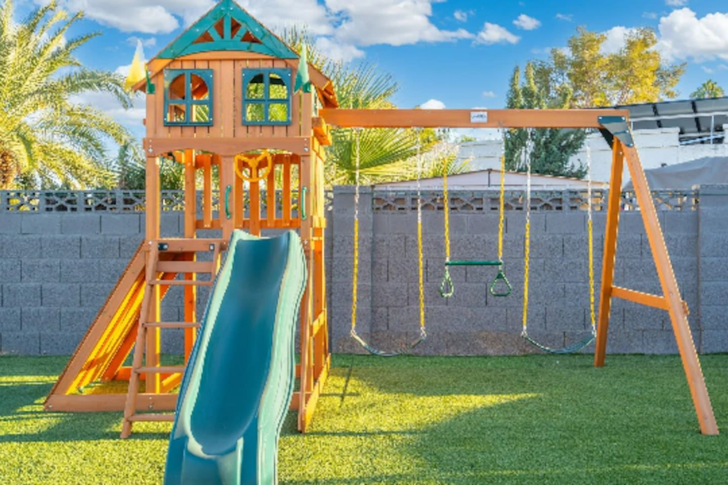 A dedicated play structure with a slide and swings gives younger guests their own corner of the yard to burn off energy.