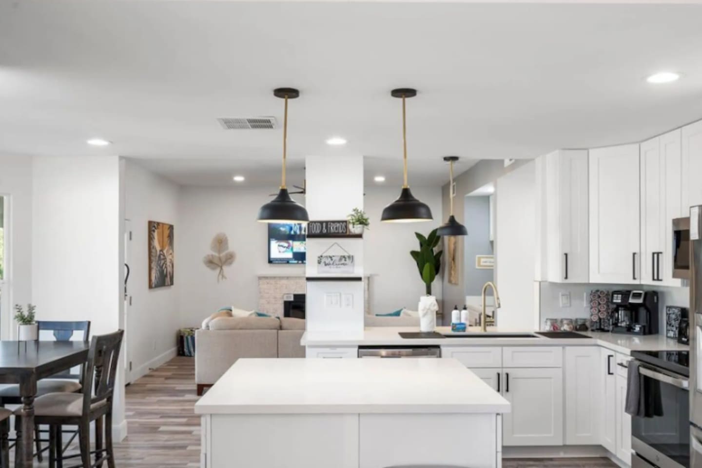 Chef's kitchen with large island, pendant lighting, and seamless flow into living and dining areas.