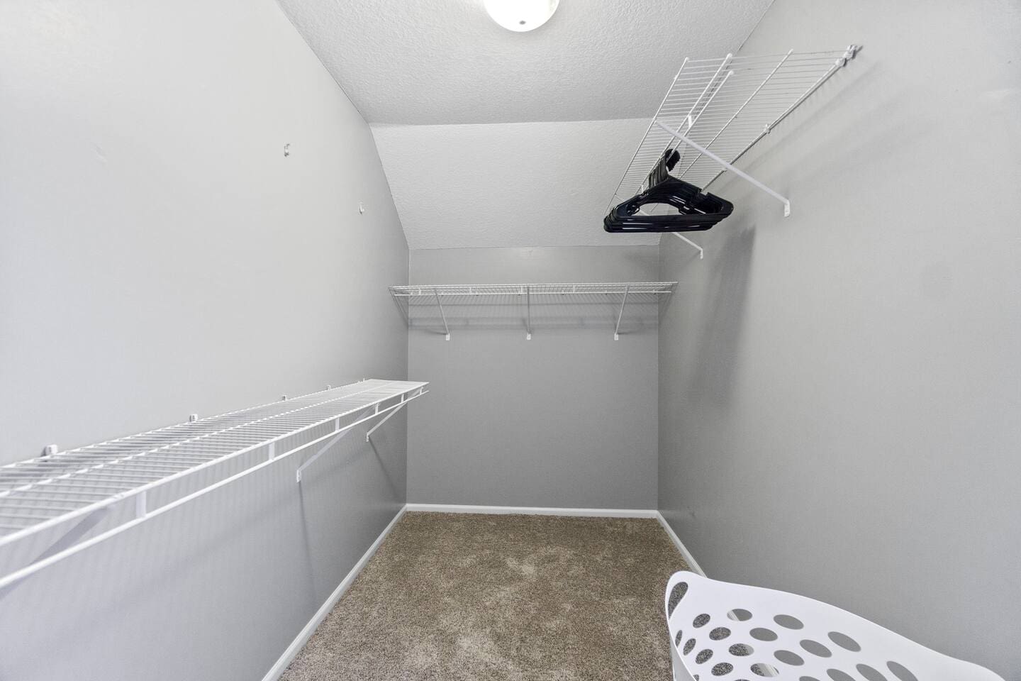 Spacious walk-in closet with built-in shelving and hanging rods.