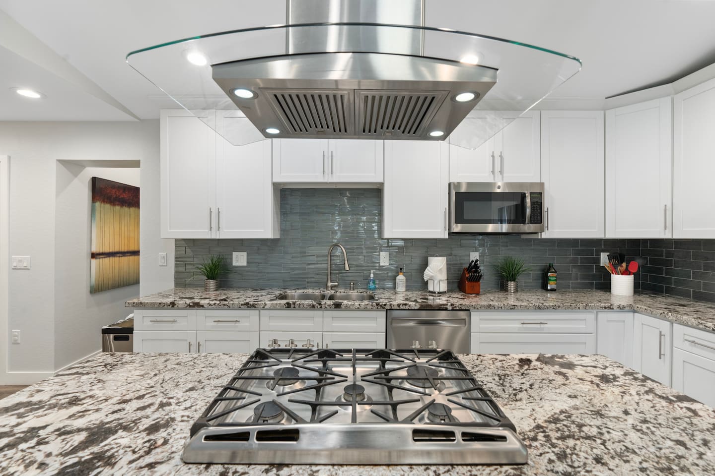 Modern kitchen featuring a central gas stove with built-in exhaust, perfect for cooking delicious meals during your stay.