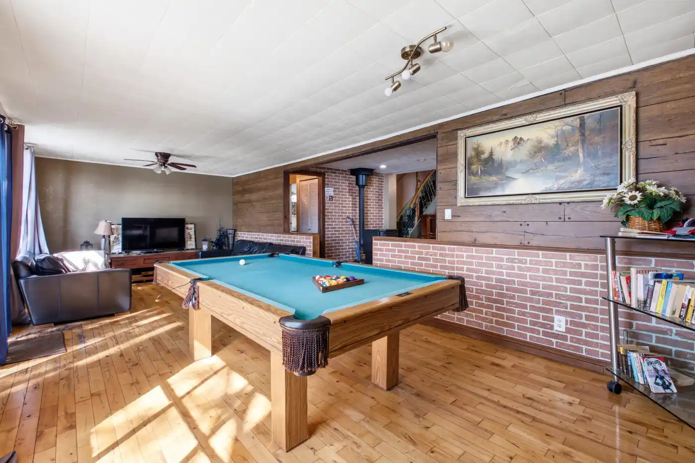 Recreation room with pool table and brick accent wall