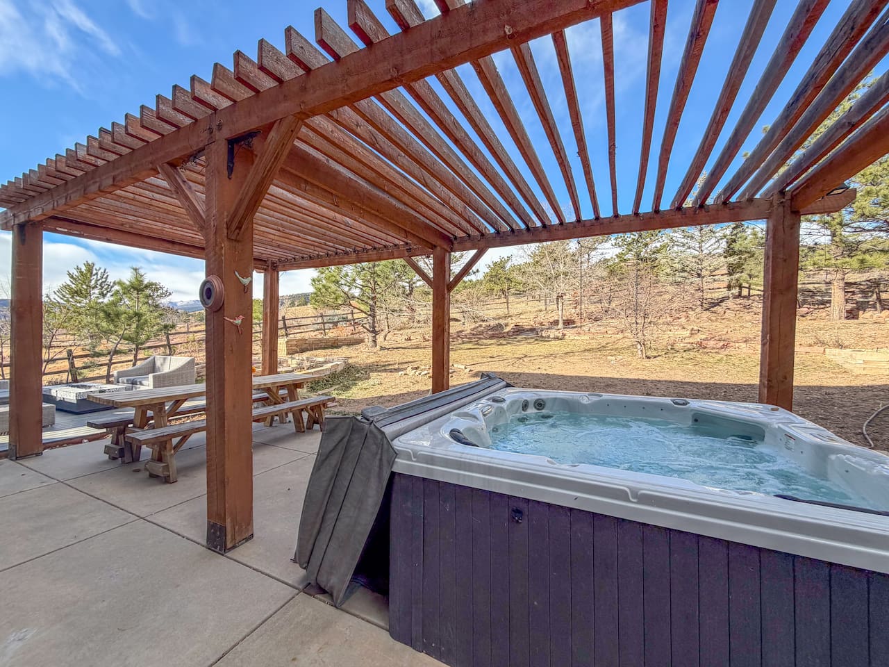 Our 6 person, cozy hot tub sits beneath a stylish wooden pergola, creating a private and inviting outdoor retreat
