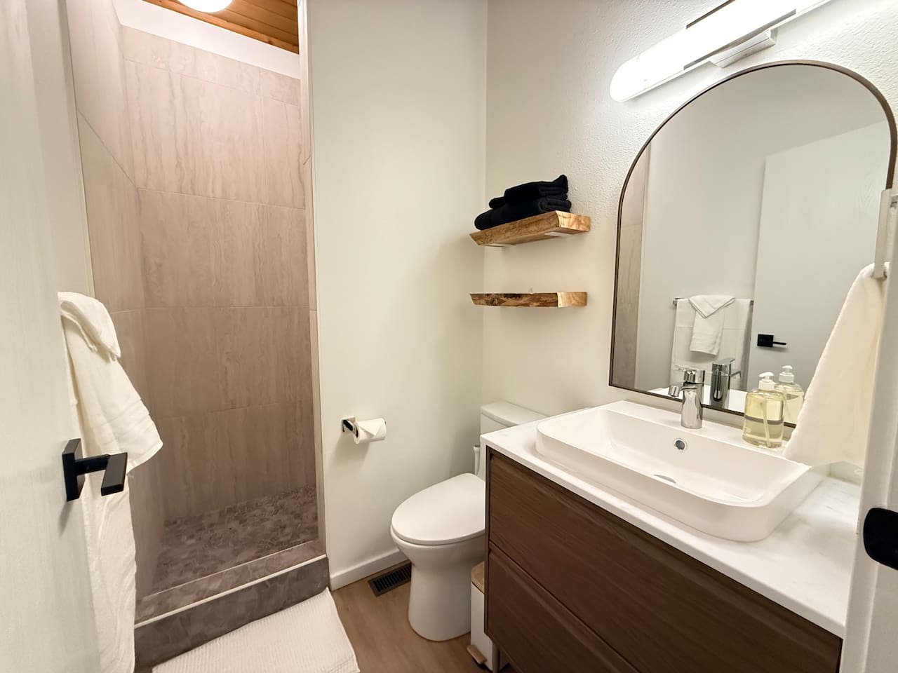 Mountain-lodge shower - tile shower with river rock base, vanity with deep drawers for bathroom items, live edge shelves for convenience and comfort height for those sore quads. 