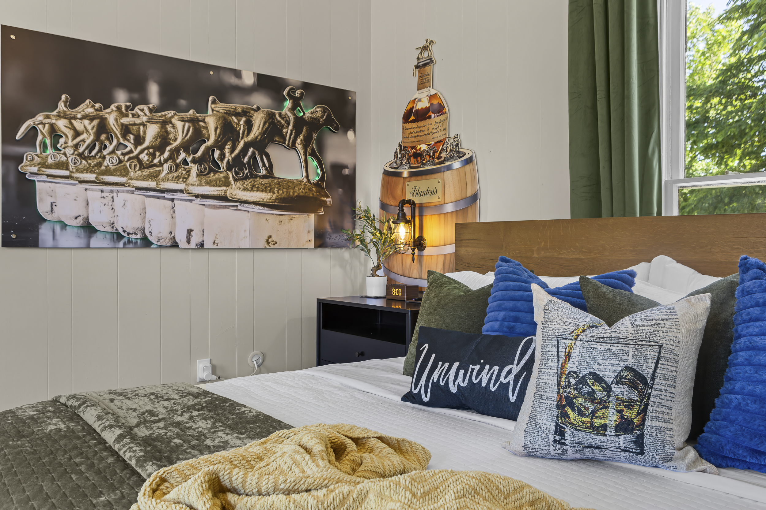 A Blanton’s barrel lamp glows softly on the nightstand, creating the perfect nightcap setting in Frankfort’s finest bottle-inspired room.