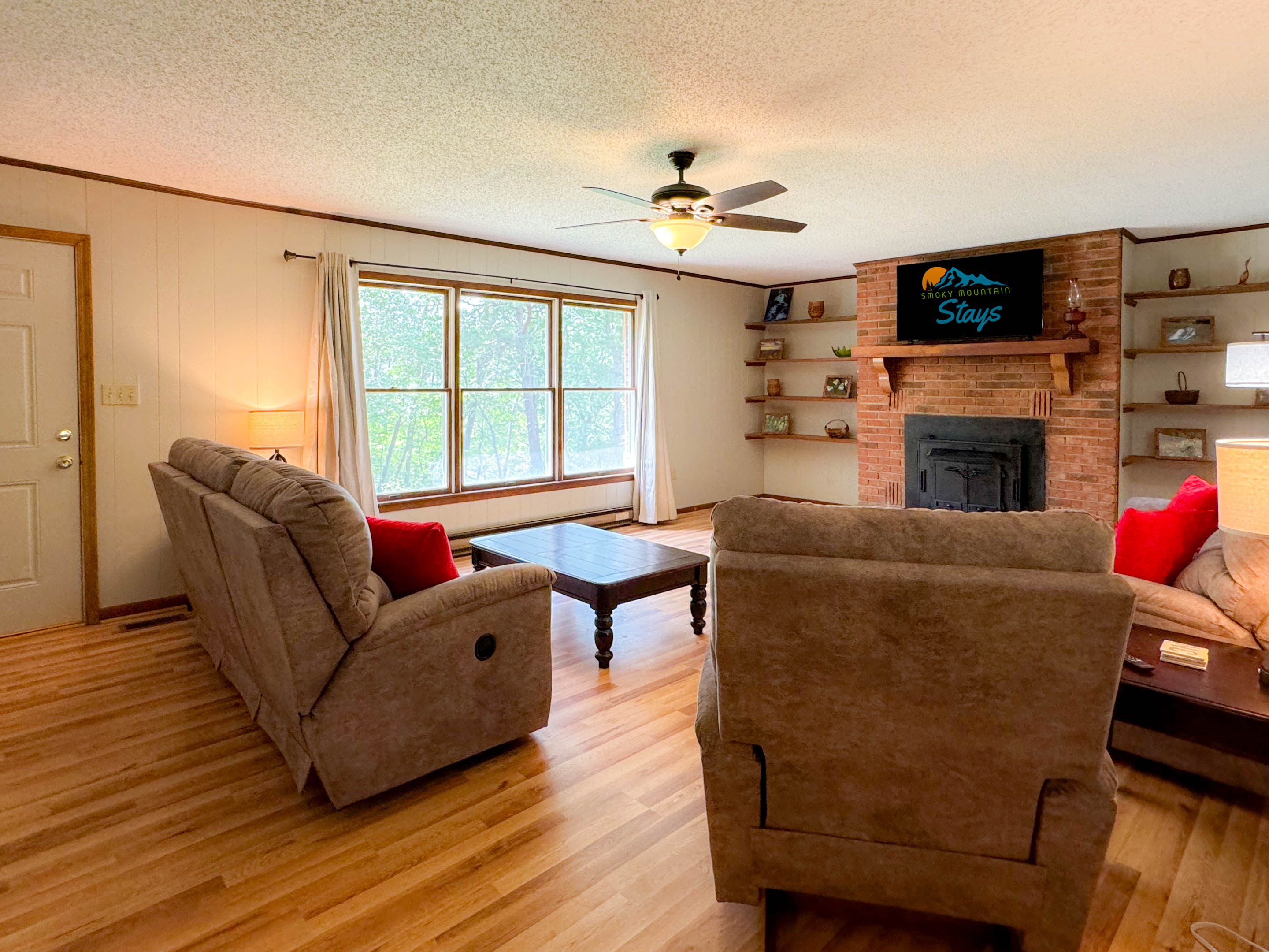 The living room is spacious and comfortable! The living room features a 48" Smart TV, reclining chairs, and a slight view of the mountains. Cherry on top! Please note the old wood stove is not a listed amenity and not available for usage at this time.