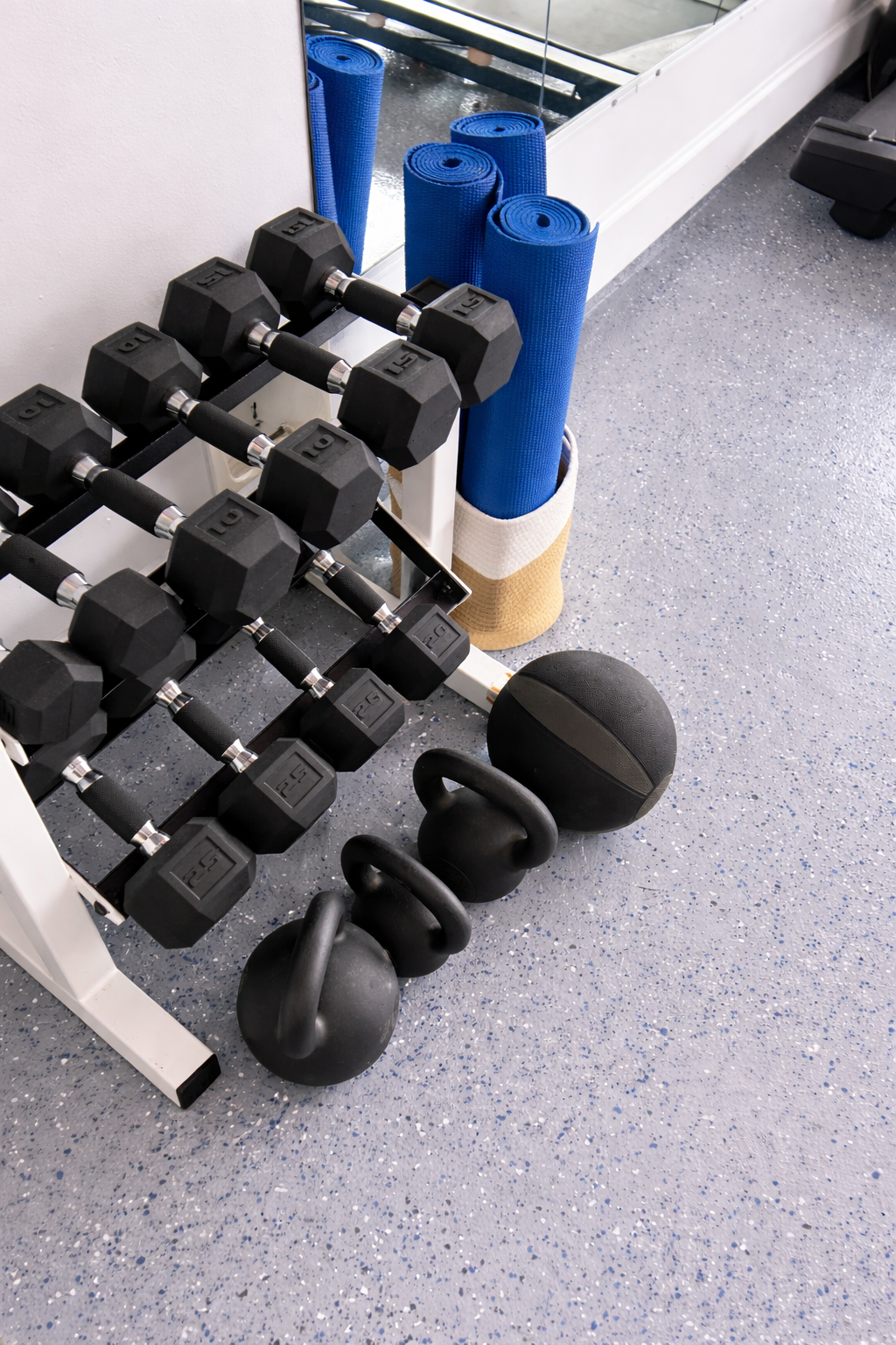 Dumbbells, kettlebells, and yoga mats for a well-rounded workout.