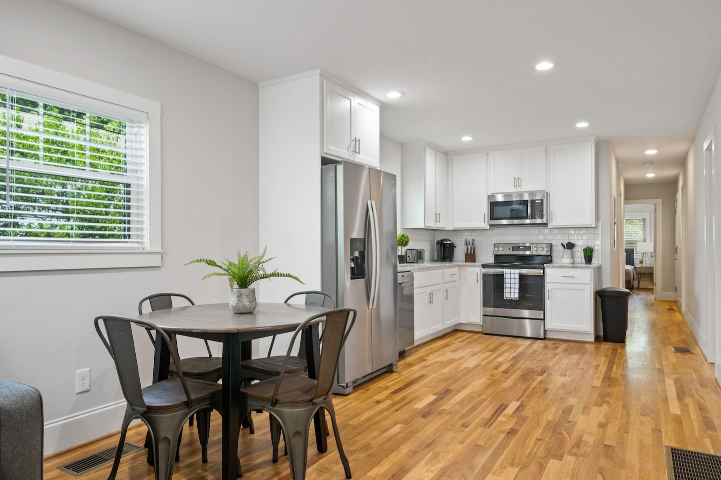 This view highlights the kitchen's expansive countertops and the adjacent dining area, emphasizing space and functionality.