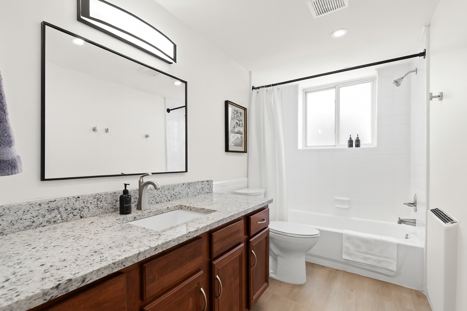 Freshen up in a sparkling clean bathroom featuring a deep soaking tub, rain shower head, soft white towels, and stylish wall art.
