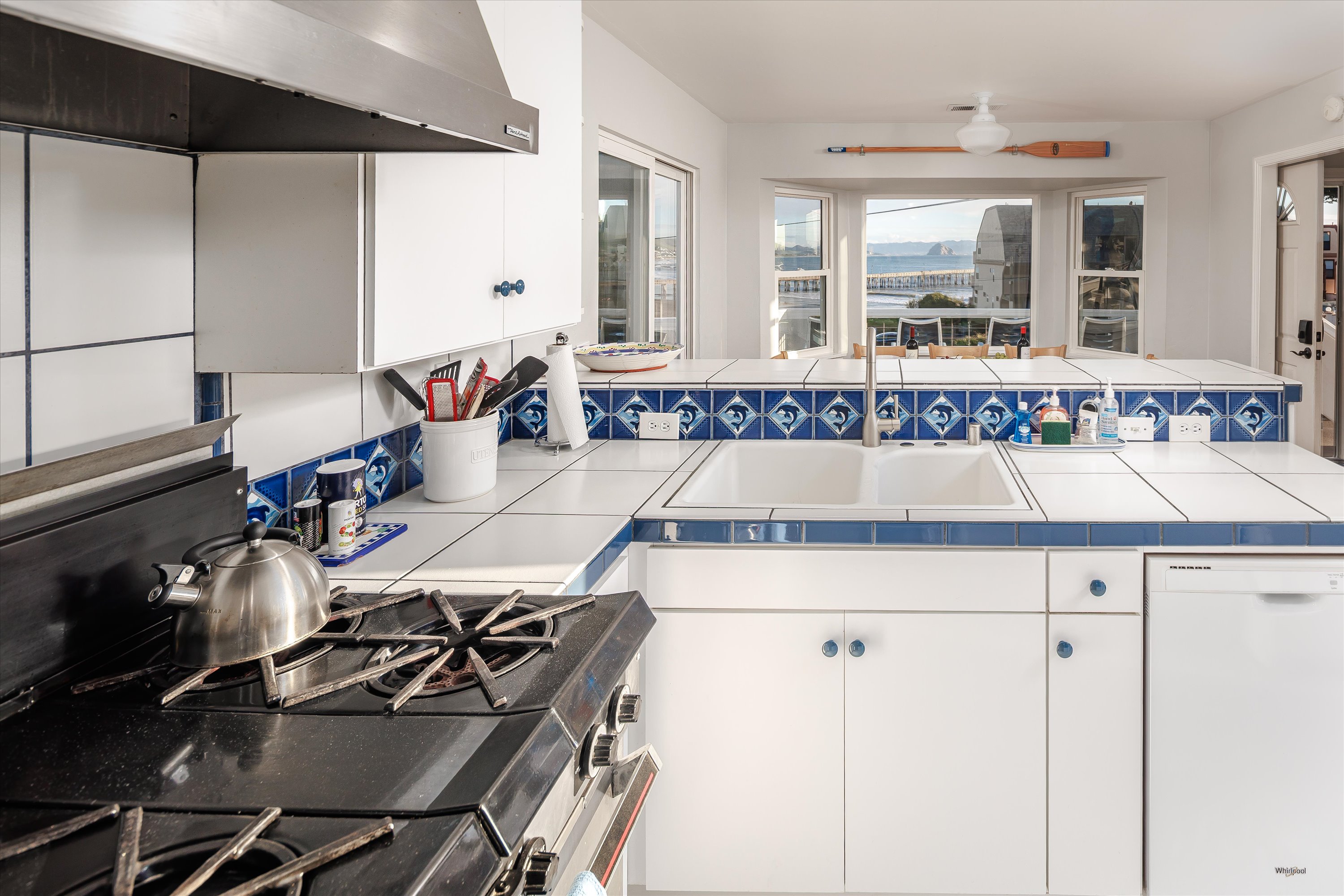Plenty of room for the whole crew — kids at the counter, cooks in the kitchen, and everyone still together enjoying the ocean view
