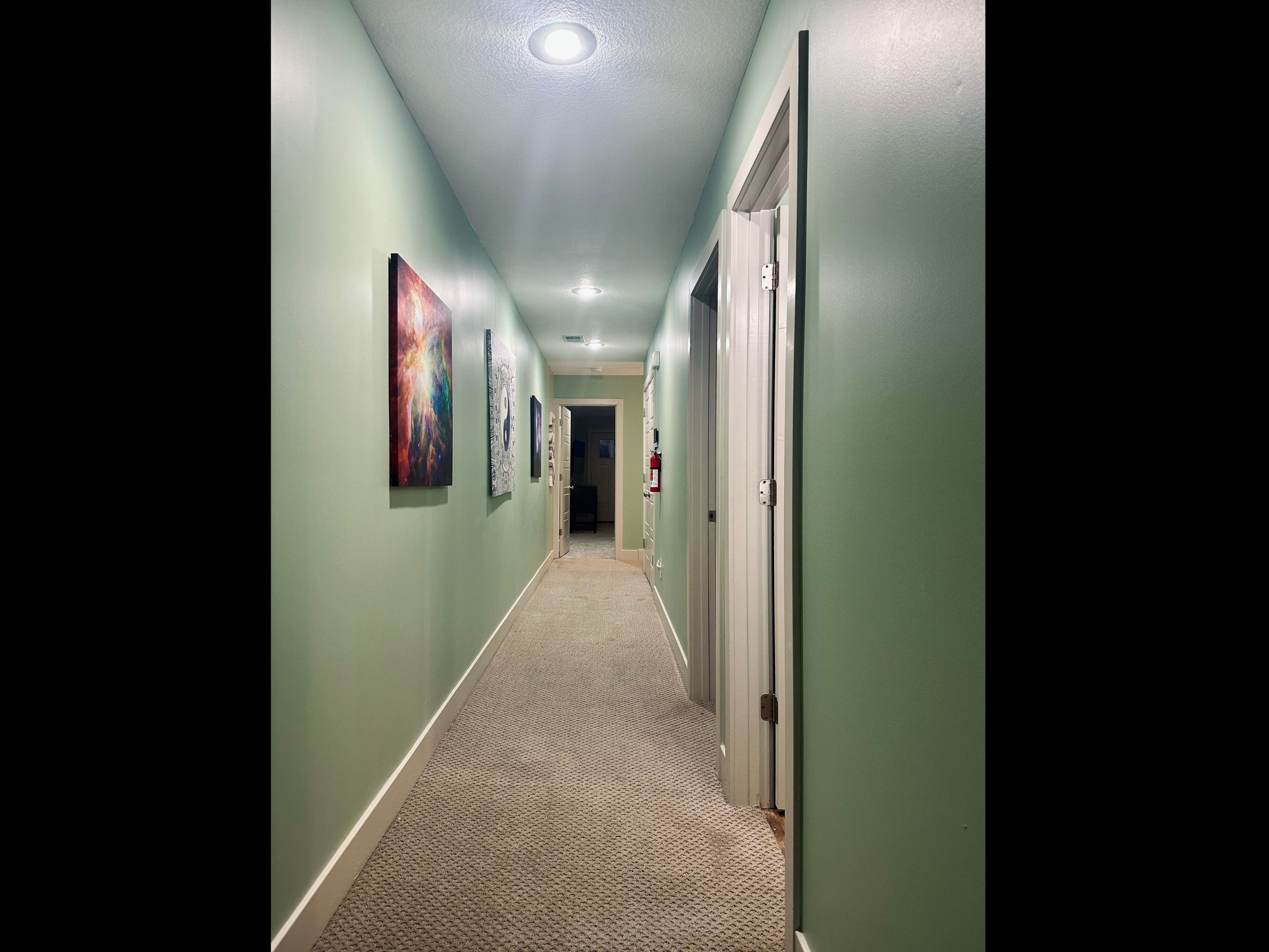 Upper-level hallway facing west toward the private primary suite, offering a calm and organized flow between spaces.