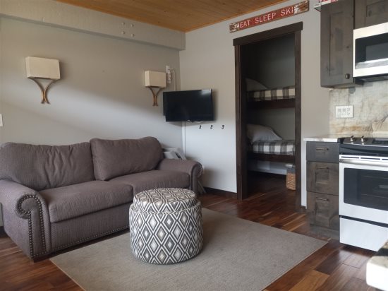 Livingroom area leading to small room with twin bunkbeds & bathroom area. 