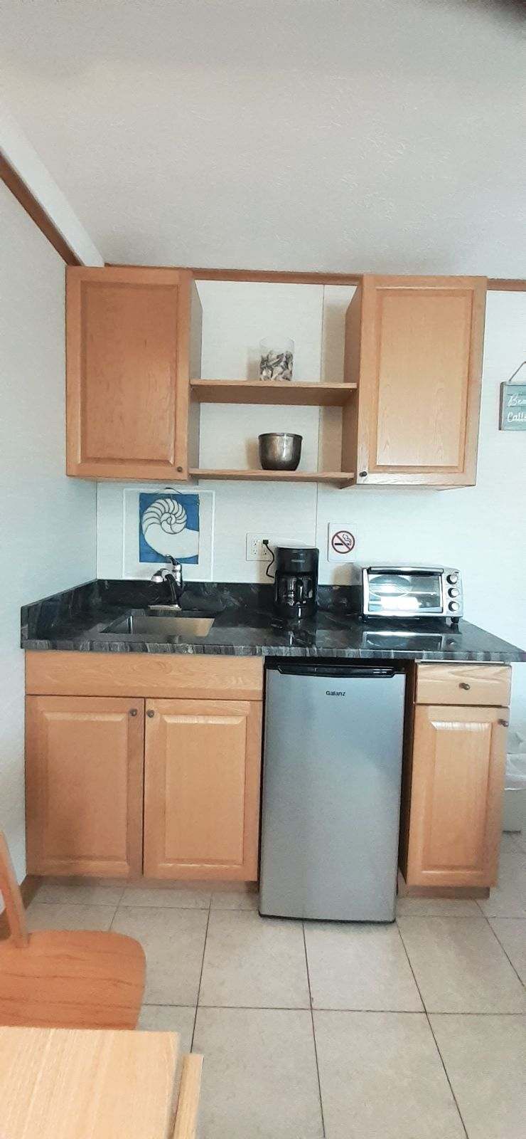 Kitchenette is complete with mini fridge, sink, toaster over, and coffee maker