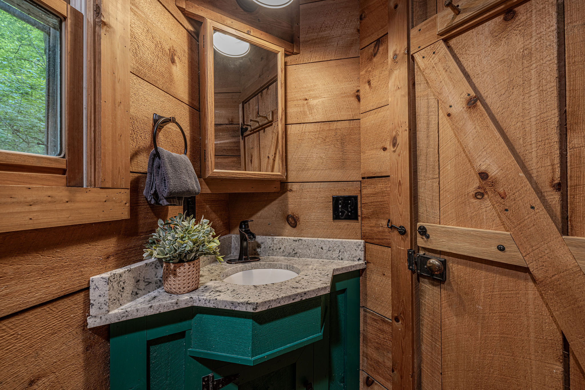 Teal vanity, granite top, barn door right behind you.