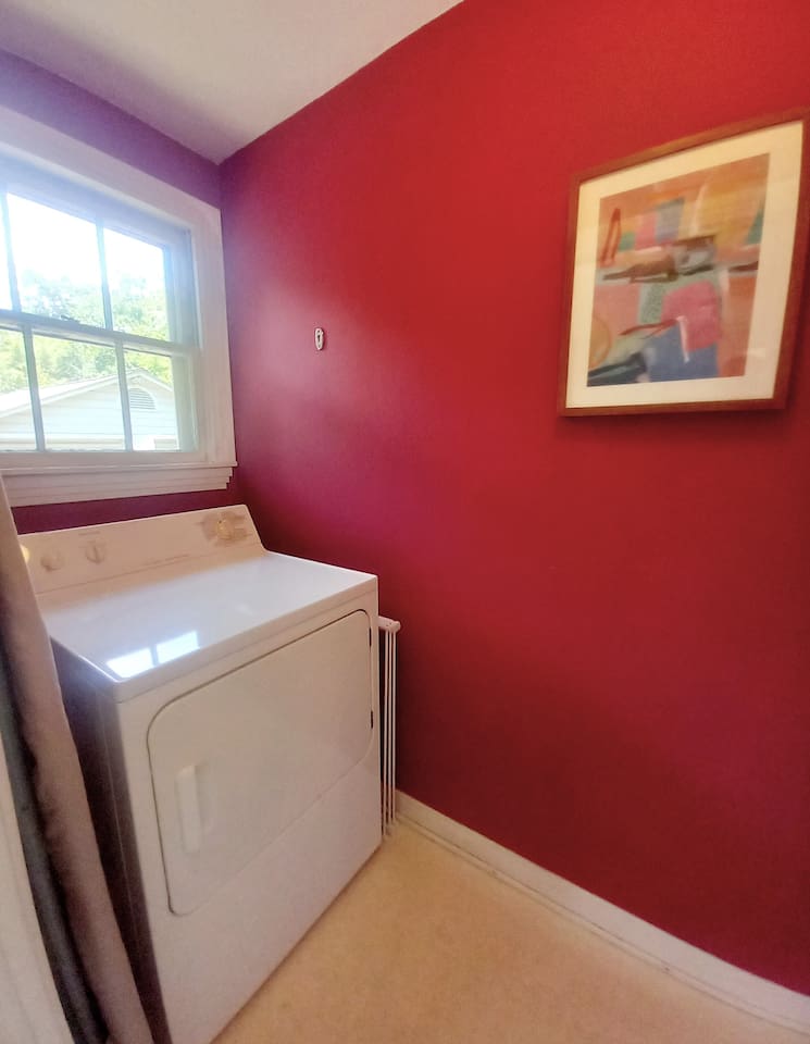 Separate laundry space includes full sized washer and dryer, ironing board, drying rack, drying line.