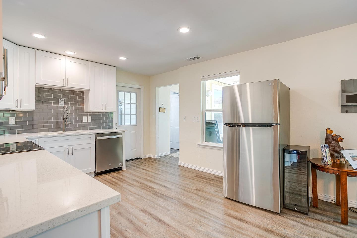 Full kitchen view with stainless refrigerator, dishwasher, and modern finishes.