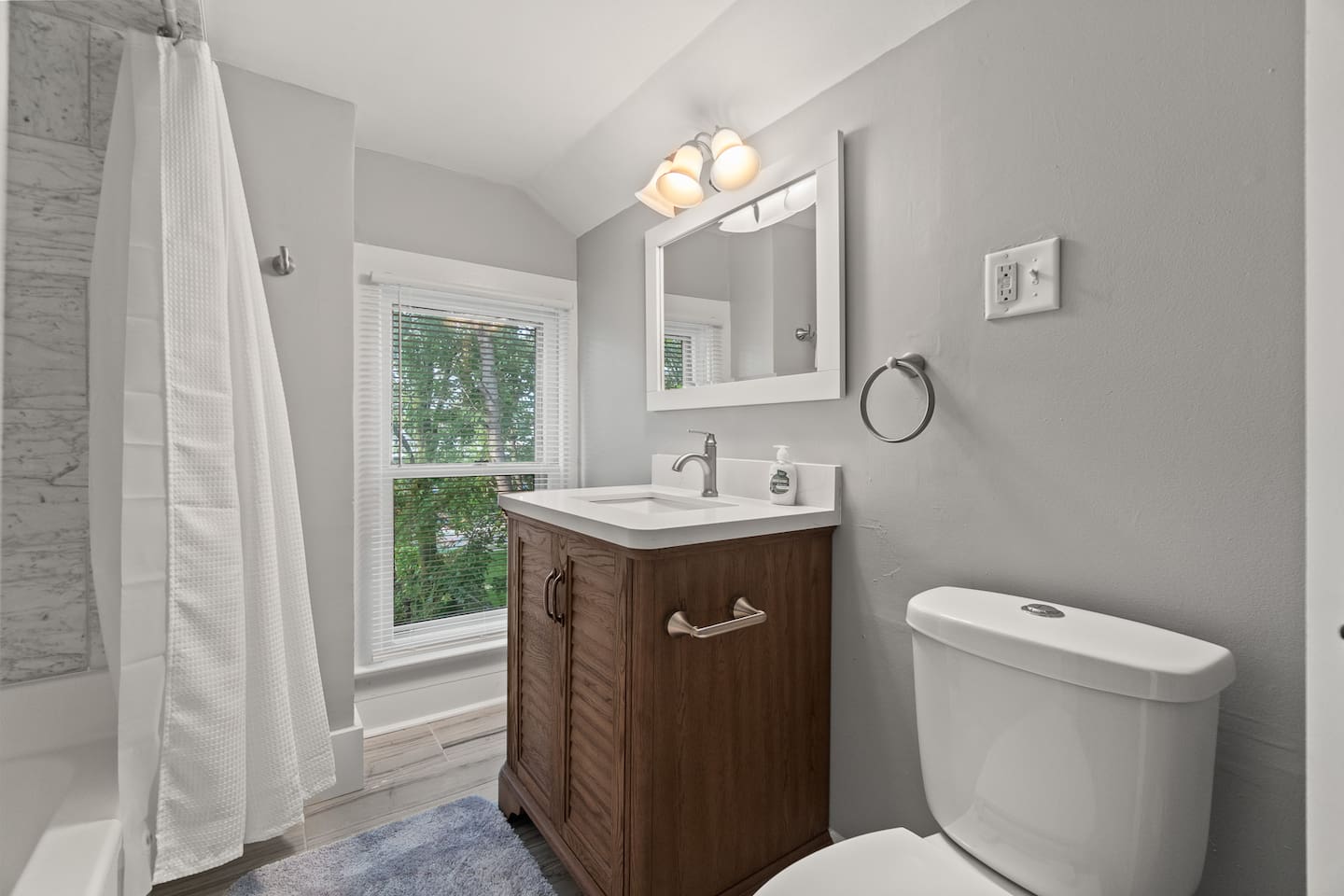Full bathroom with vanity, natural light, and tub/shower combo.