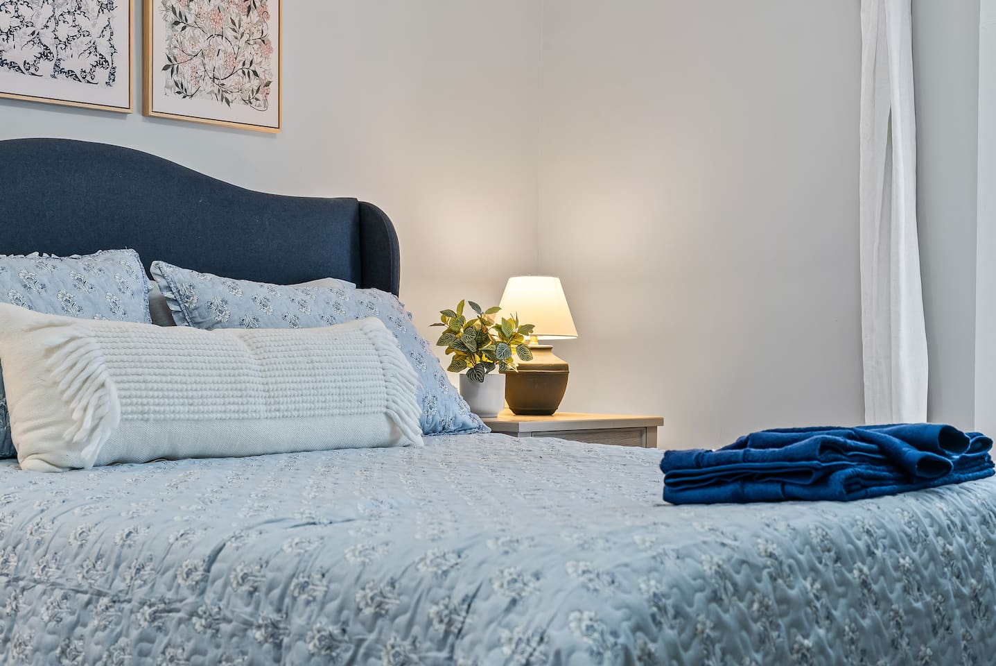 Soft linens and a bedside lamp create a cozy spot to read before lights out.