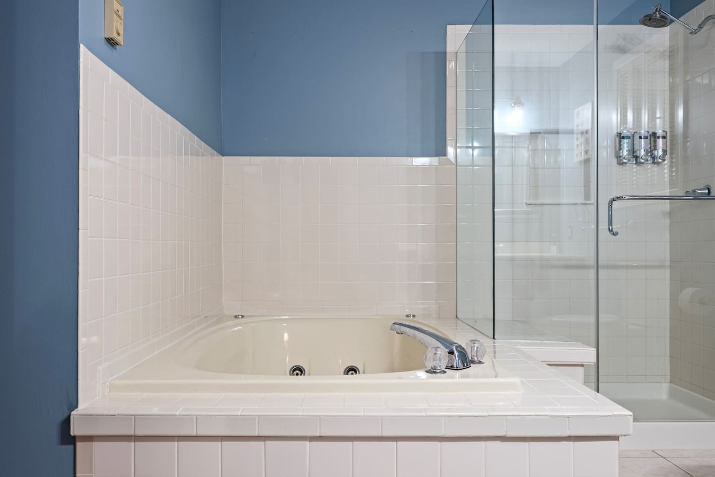 Hall bathroom with glass shower and oversized tub.  Note - the jets are not functional.