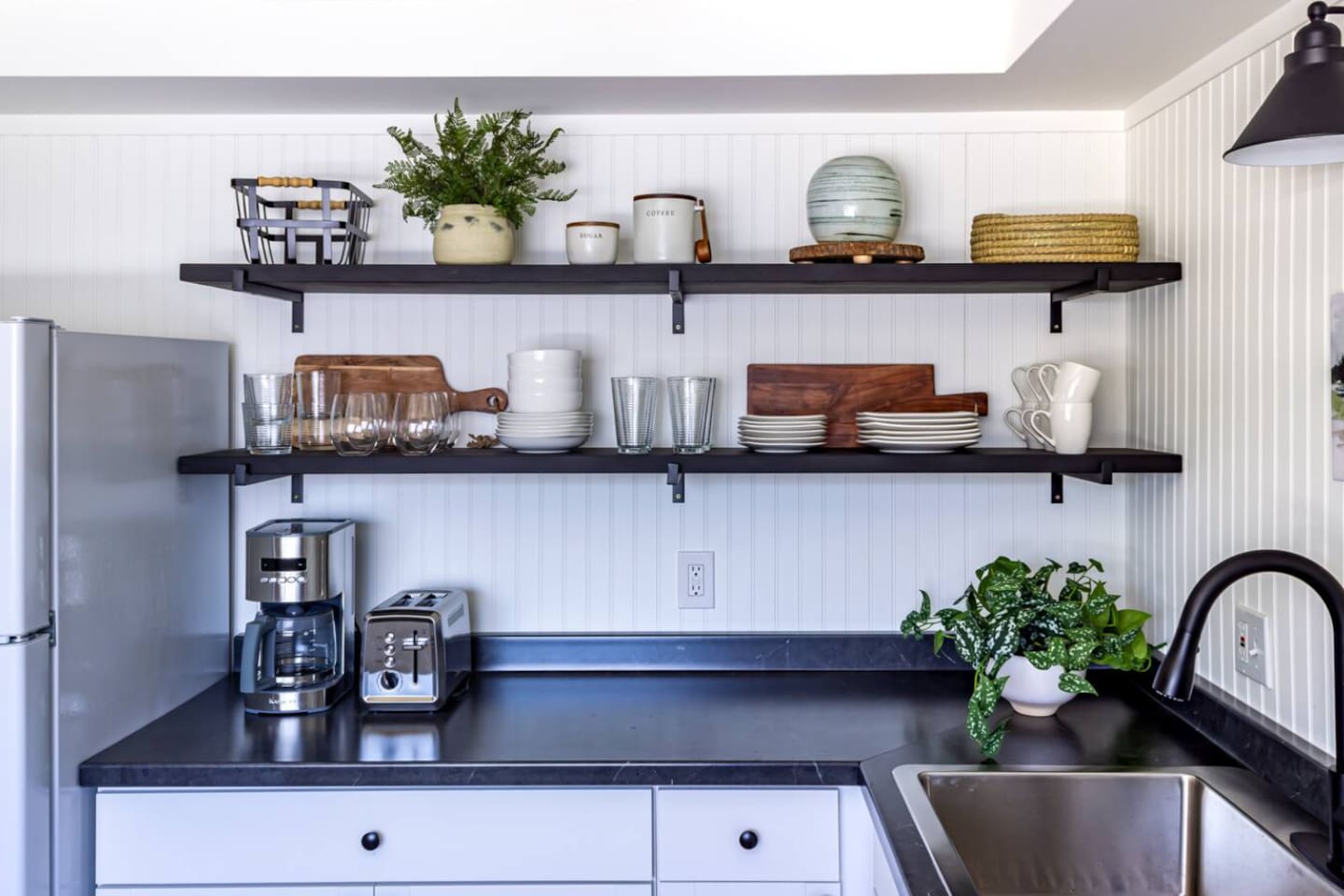 Open shelving and a coffee bar ready to go — mornings start easy in this kitchen.