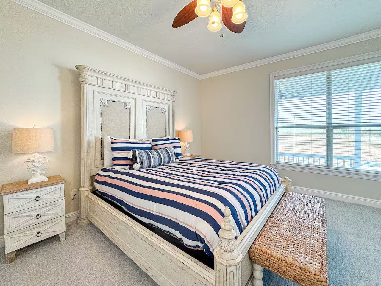 Spacious bedroom with a comfortable bed, fresh linens, and warm lighting. Includes bedside tables, ceiling fan, and cozy seating for a relaxing stay.