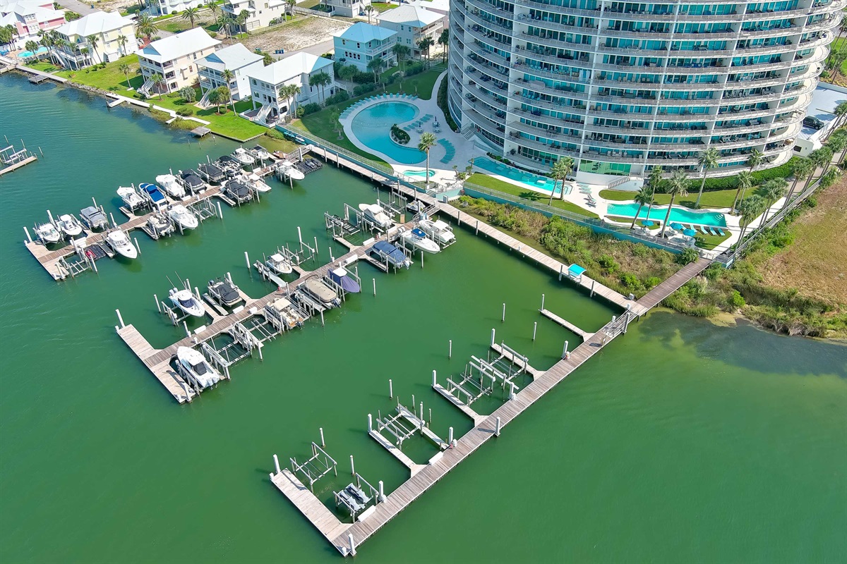 The gentle sway of boats in a secluded marina, with the shimmering Gulf providing a breathtaking backdrop. An exclusive waterfront haven.