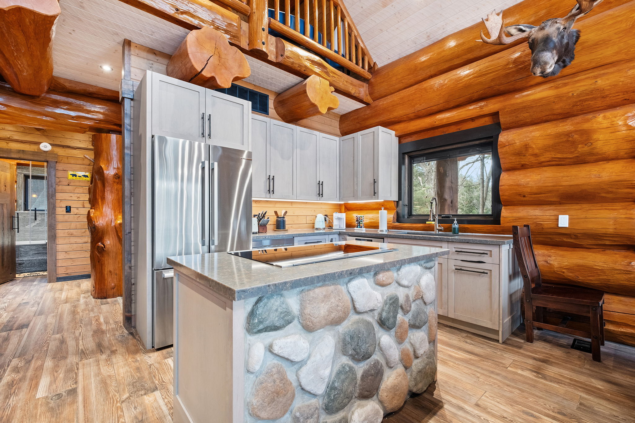 Modern chef’s kitchen with stainless-steel appliances, stone-faced island, and plenty of counter space for cooking.