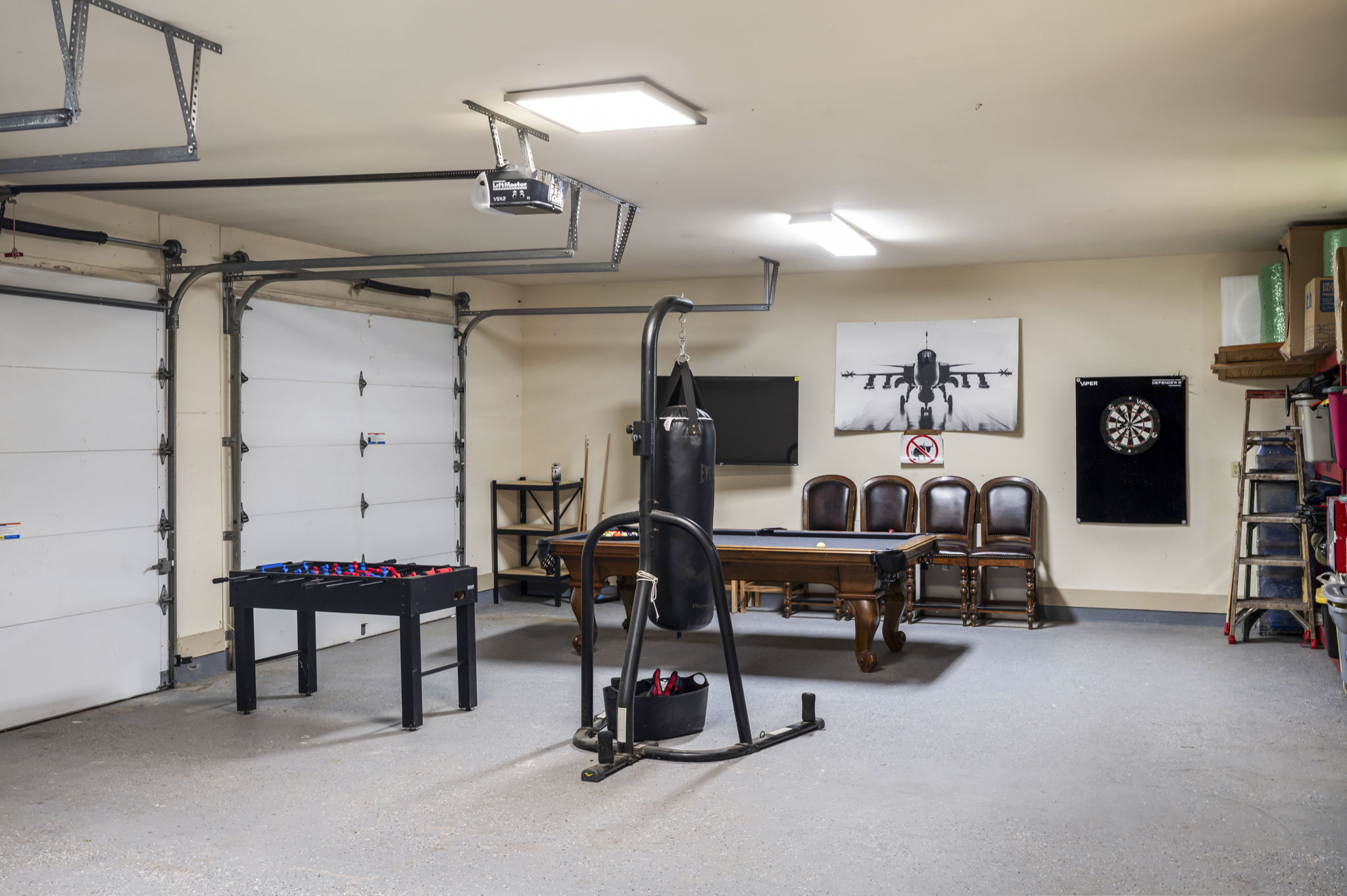 Located at the back of the house, this versatile space is set up as a game room featuring a billiards pool table, foosball table, darts, and a punching bag for active fun.