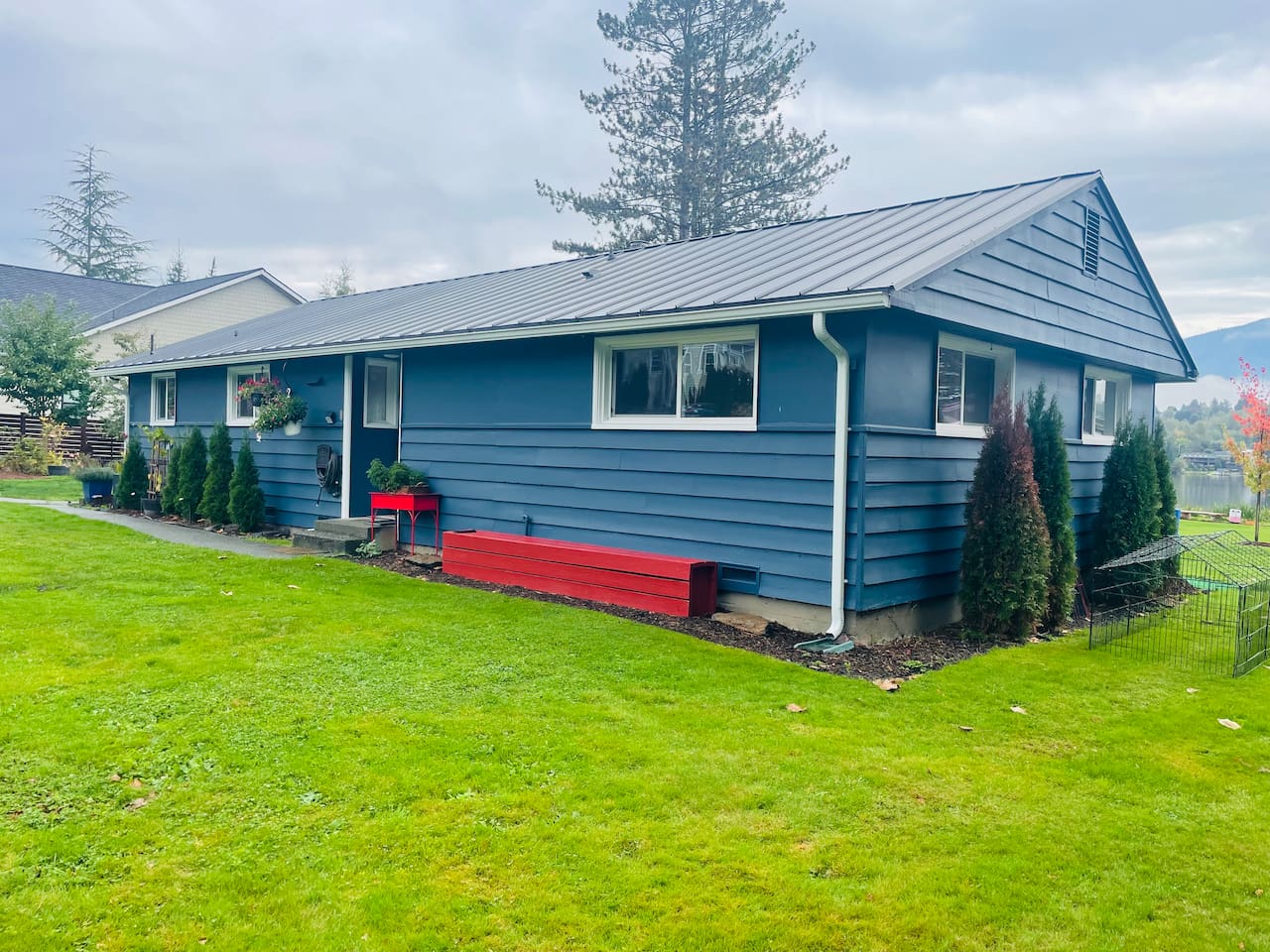 A single-level lakeside home with blue walls and red accents, blending charm and calm in a welcoming setting.