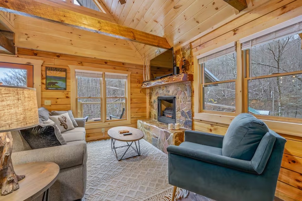 Cozy up around the stone fireplace in the main living room at Bear Paws Cabin. A wall-mounted Smart TV, plush seating, and a crackling fire make this the ultimate family movie night setup after a long day exploring Gatlinburg or hiking in the Smokies