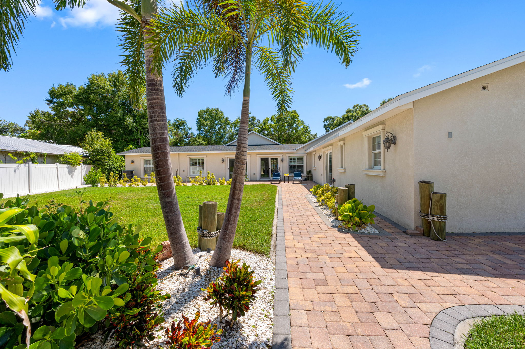 Brick walkways lead you through manicured gardens and open lawn areas, creating a resort-like atmosphere right in your backyard.