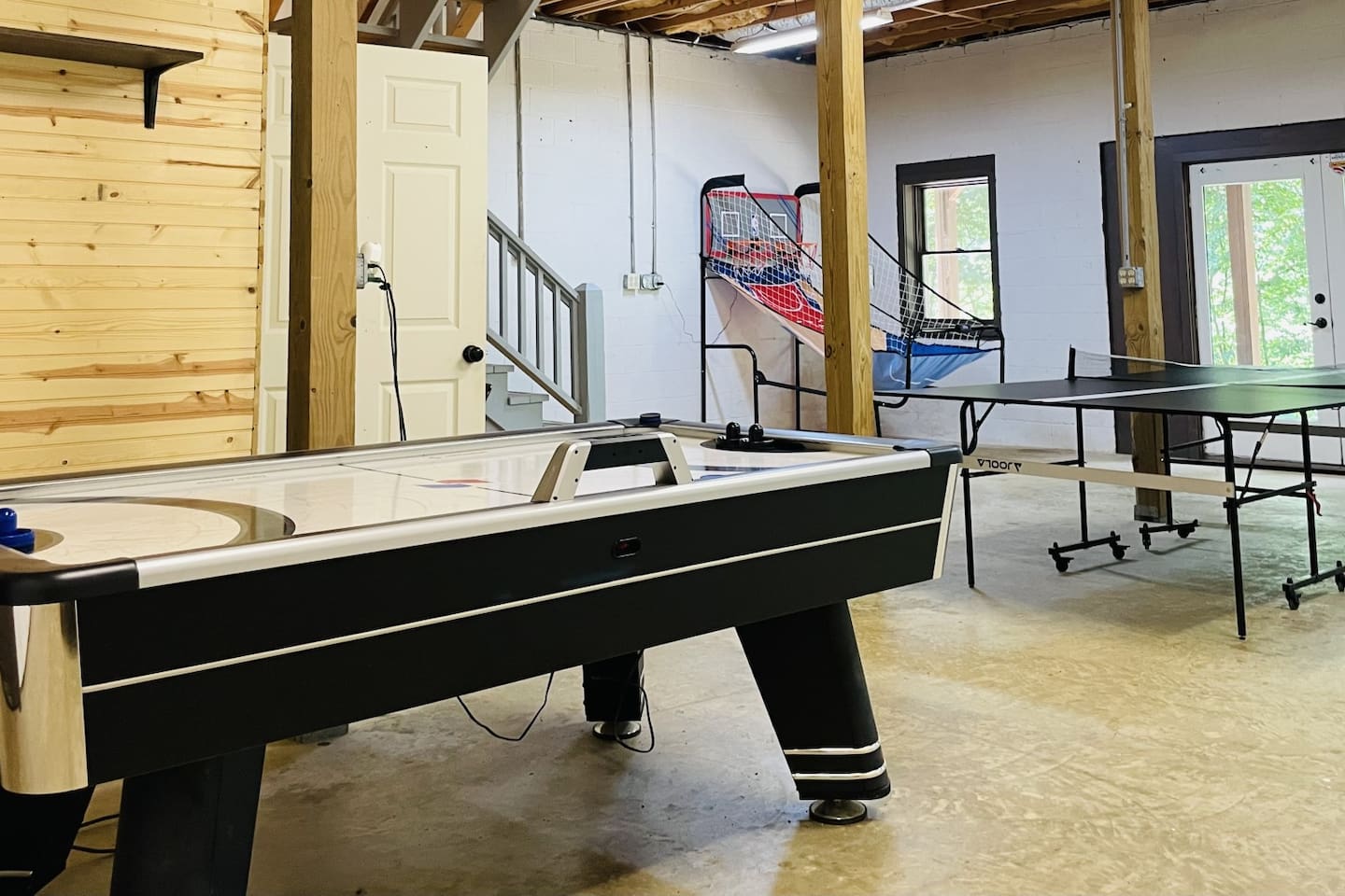 Basement play palace has ping pong, air hockey, a basketball game, cornhole, gaming table, and a bonus den