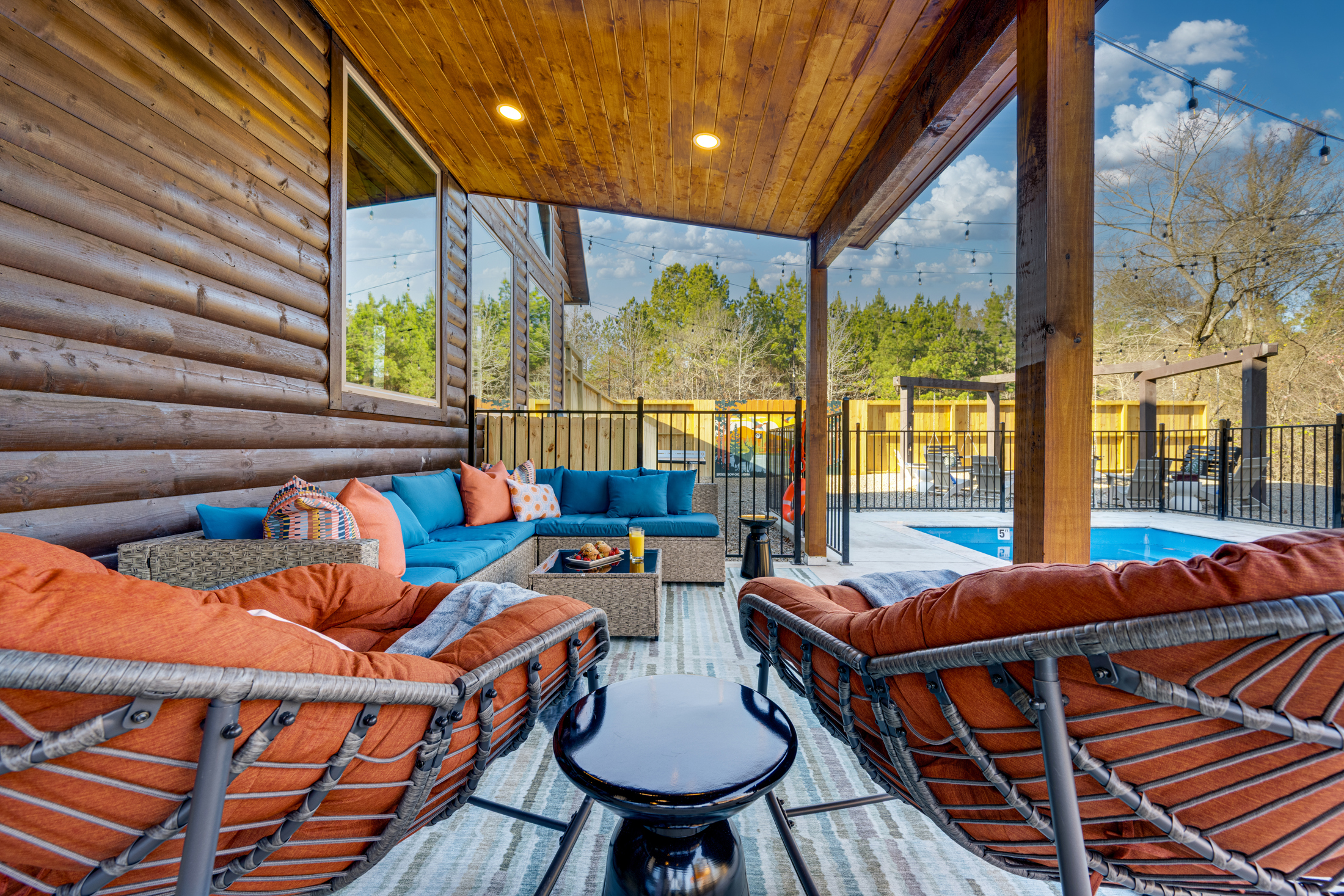 Outdoor Lounge: Unwind in vibrant seating with pool views and twinkling lights overhead!
