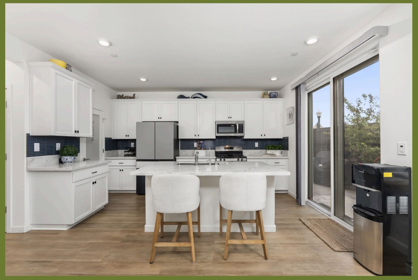 Kitchen with seating, stainless steel appliances, sliding patio access, and bright open space for everyday meals.