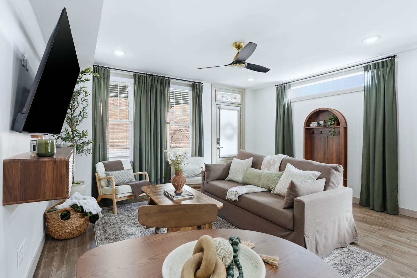 Bright and inviting living room with cozy seating, stylish decor, and large windows that bring in beautiful natural light—perfect for relaxing after a day exploring Fort Wayne.