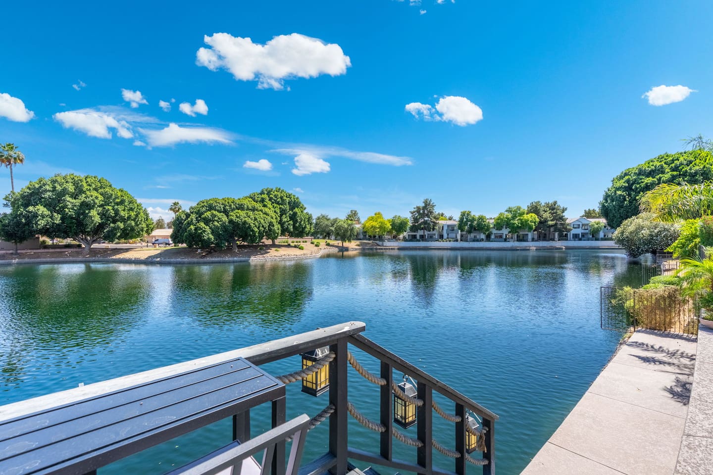 Step down to the dock and take in the full sweep of the lake — a serene, palm-lined panorama that feels a world away from the everyday.