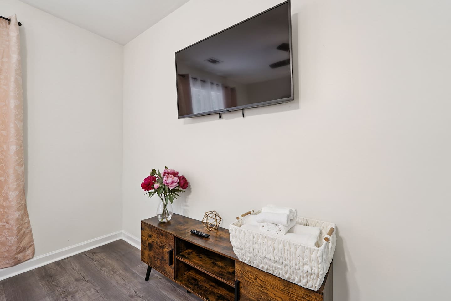 Master bedroom featuring a comfortable king bed and an Amazon Fire-powered Smart TV. The shared bathroom is conveniently right next door. This room includes 2 full-body towels, 2 washcloths, and 2 hand towels for your stay.