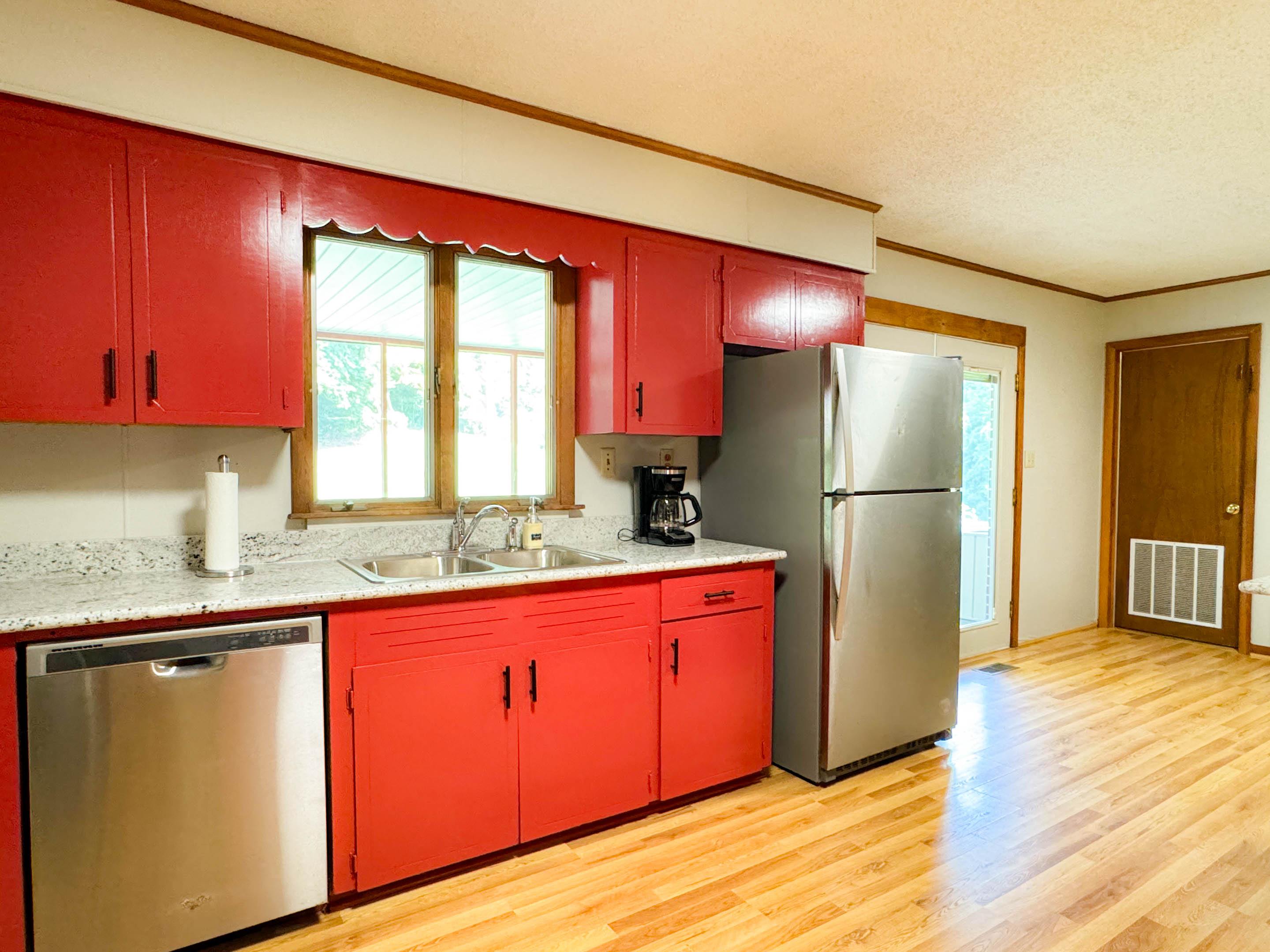 Drip coffee maker, large refrigerator, dishwasher, and dinnerware.