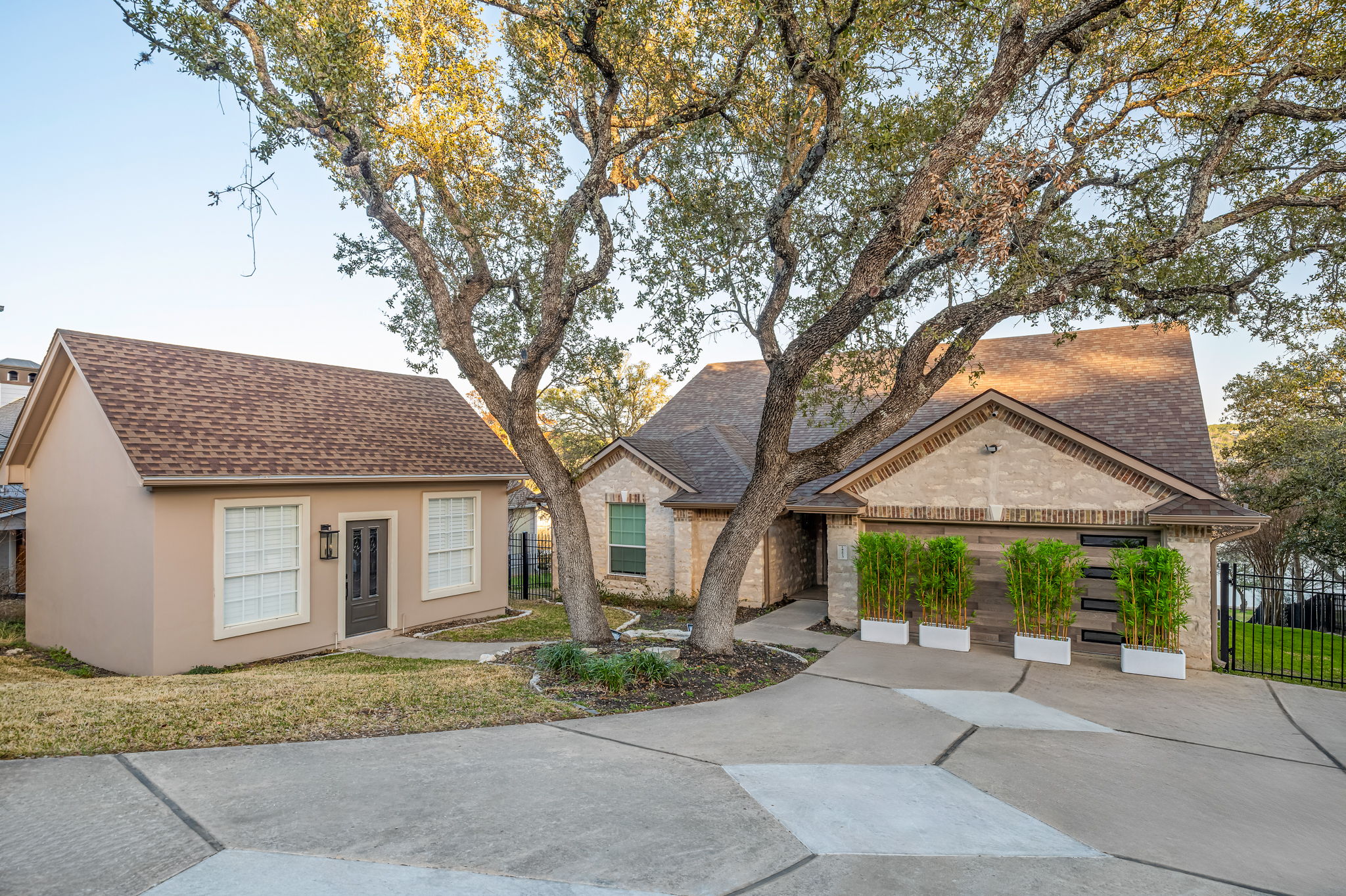Welcoming front exterior with spacious driveway and mature trees.