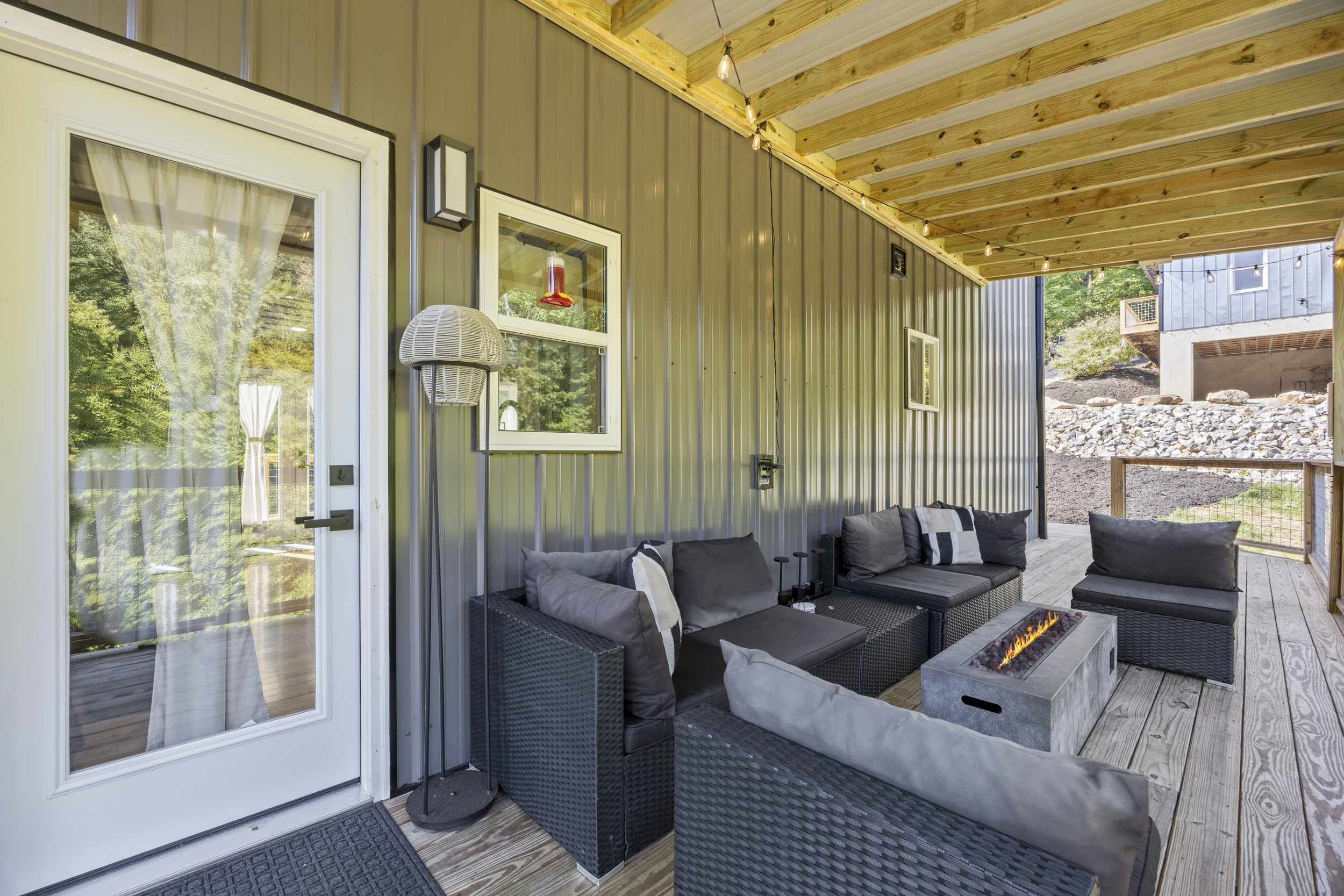 Covered deck with fire table and seating — enjoy the outdoors in any season.