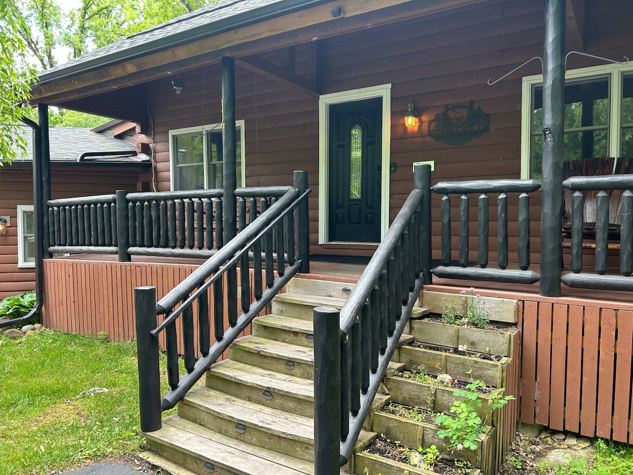 Stairs leading to front porch of log cabin.